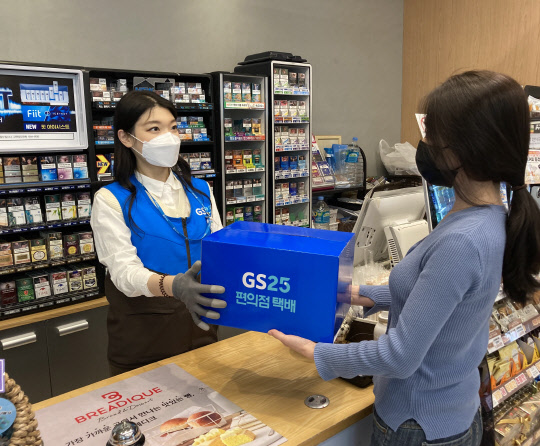 고객이 GS25에서 점원에게 반값택배로 보낼 물품을 건네고 있다. GS25 제공